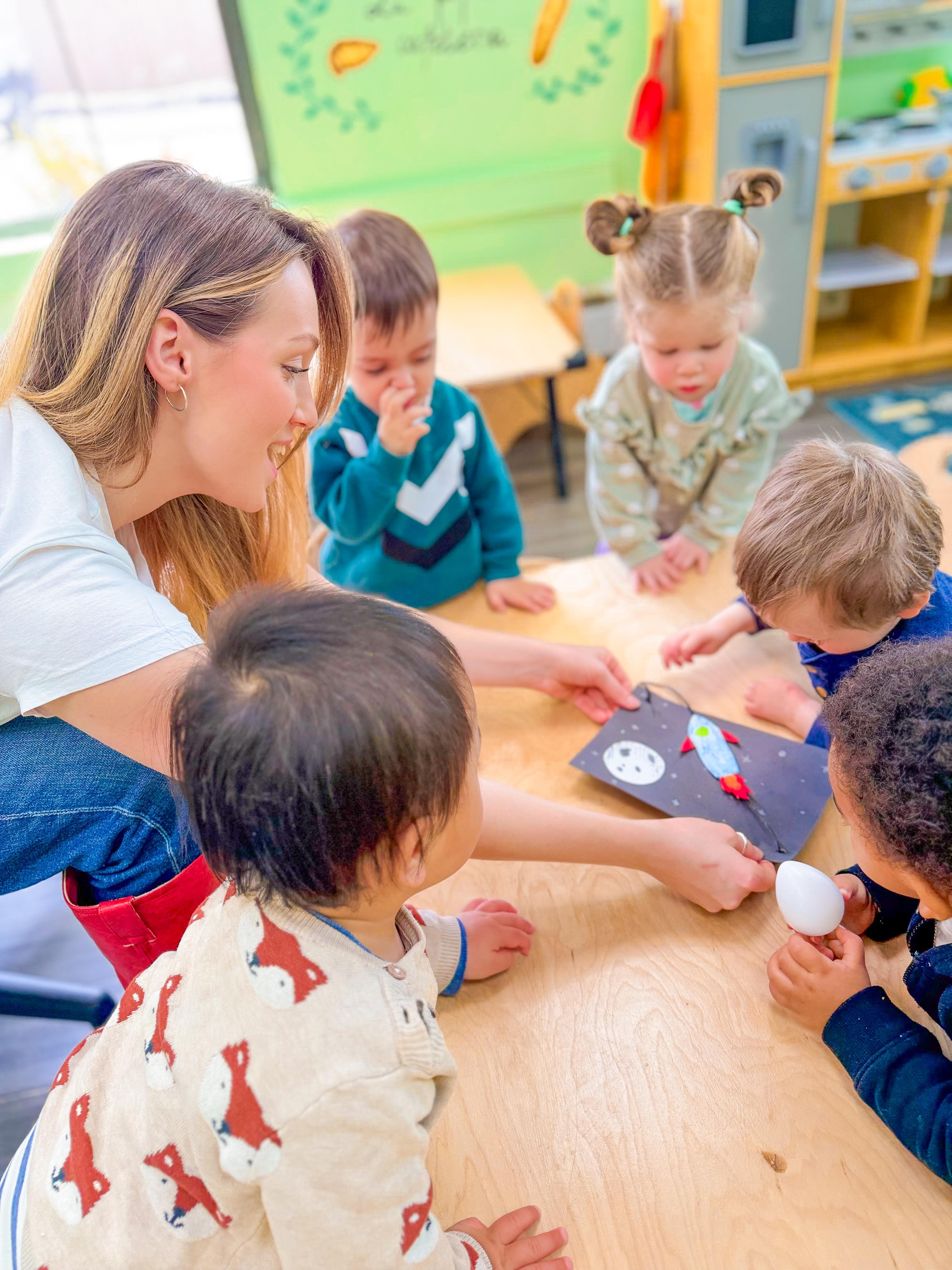 Teacher guiding children through a hands-on classroom activity at Global Children School Woburn
