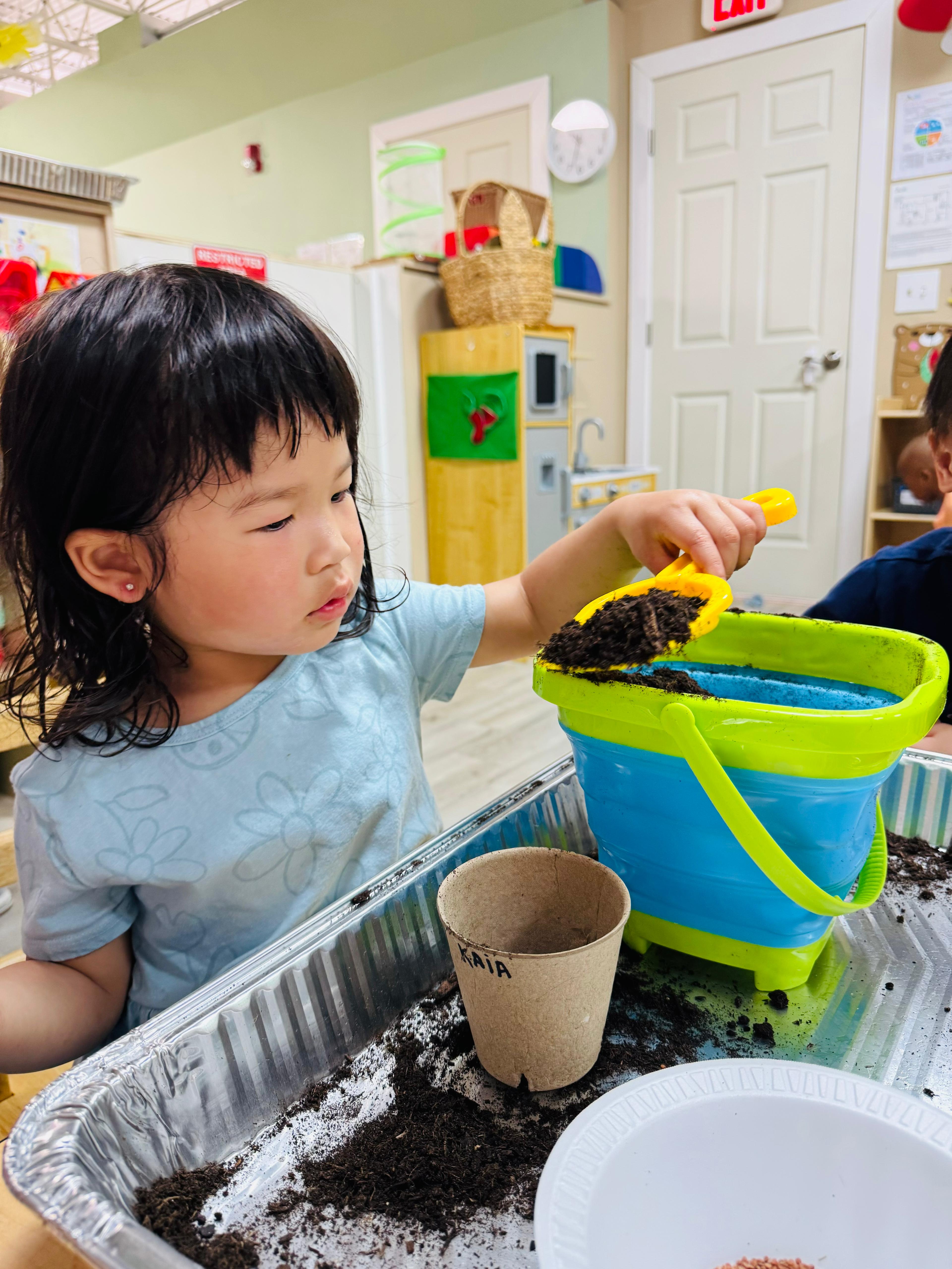 Child planting and exploring nature in a vibrant Woburn classroom